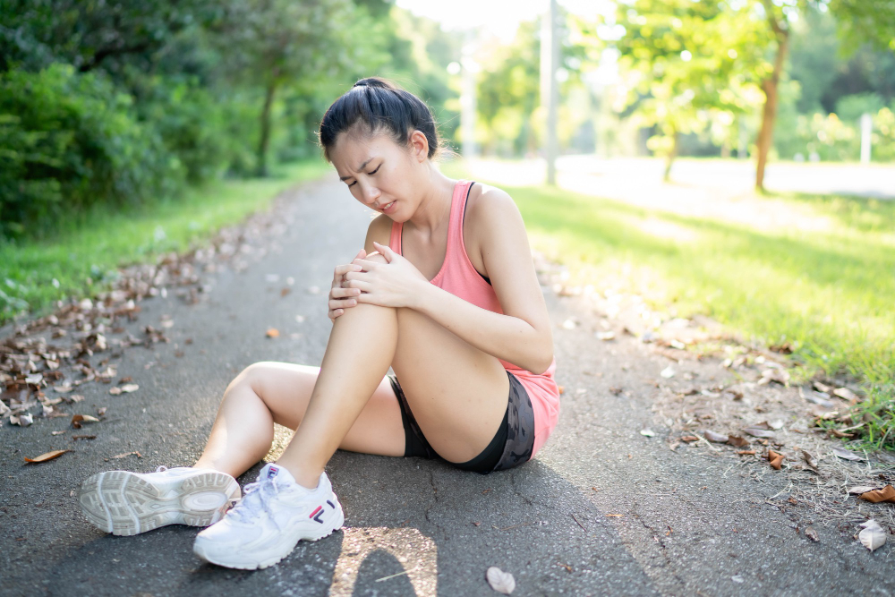 asian woman injured her leg knee while running park