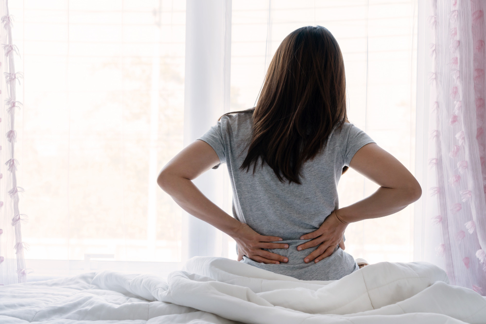 sad young asian woman touching back feeling backache morning discomfort low lumbar muscular kidney pain sit bed after bad sleep waking up uncomfortable mattress bending concept woman stretch 1